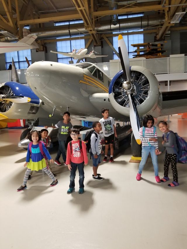 kids posing infront of plane